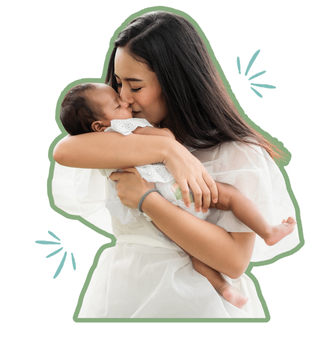A woman holding and kissing a small infant